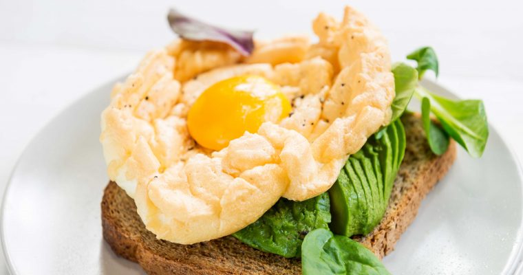 Cloud eggs met avocado en veldsla op geroosterd brood